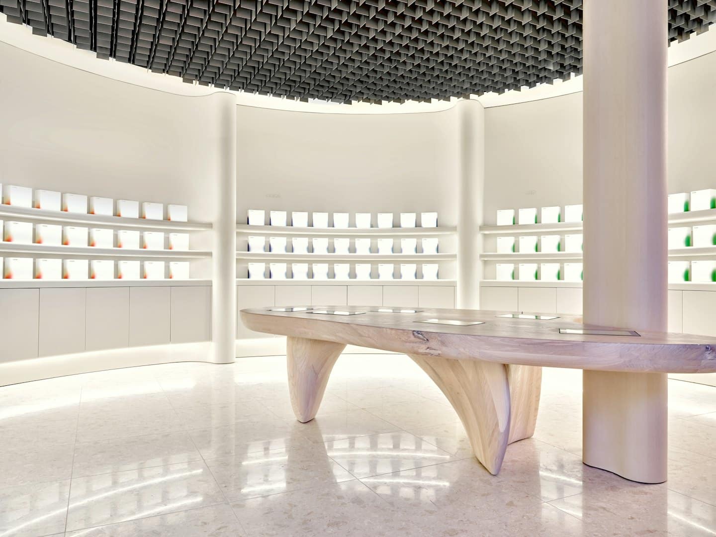 Modern retail interior with illuminated shelves and a wooden table.